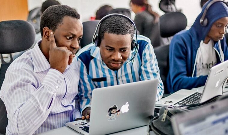 2 African guys working on a macbook computer.