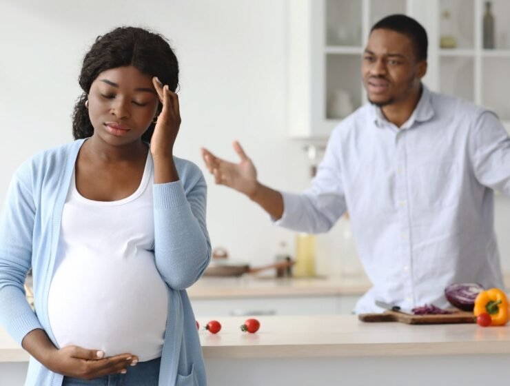Pregnant woman and man arguing in the house